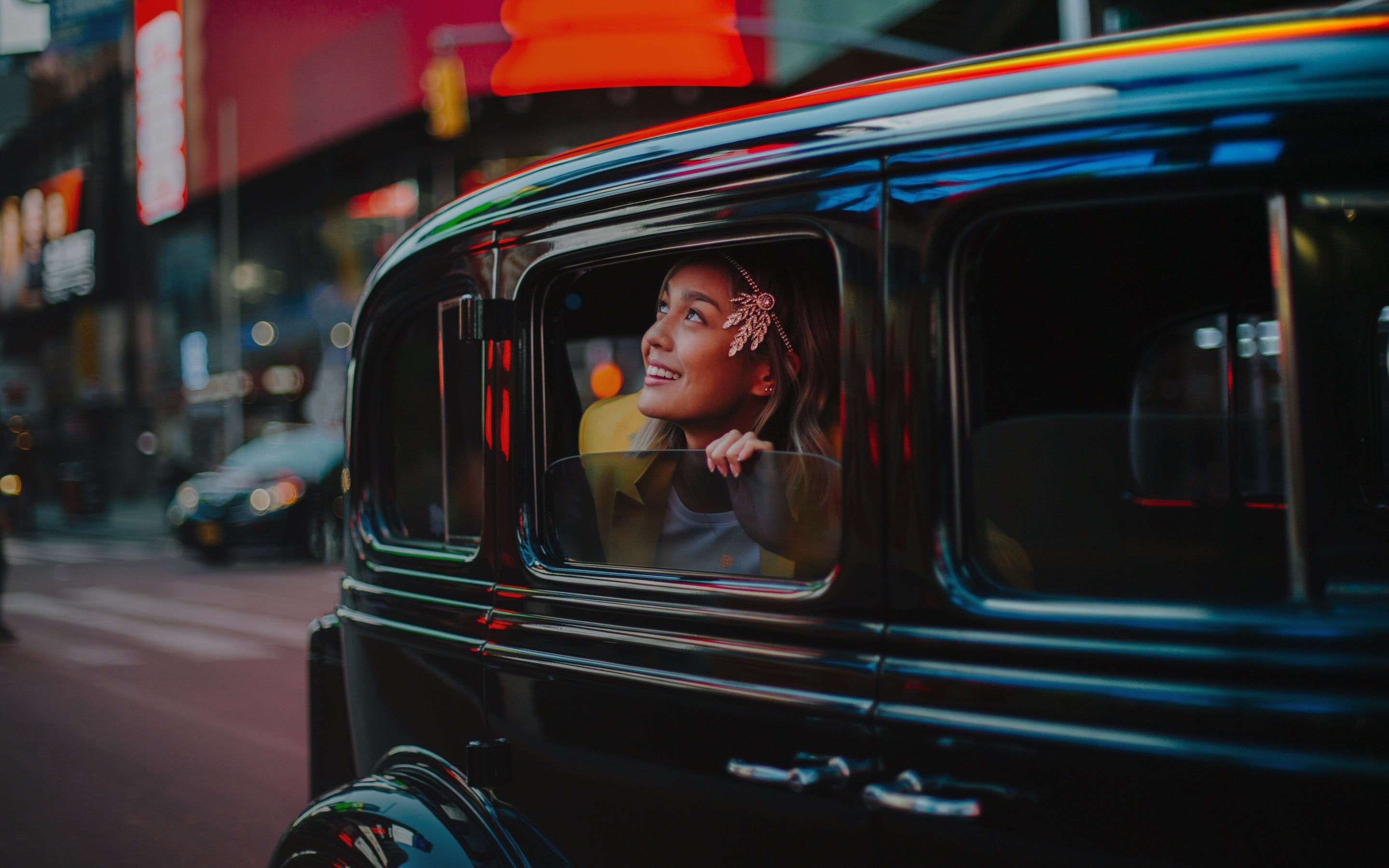 Woman looking outside of vintage car at times square