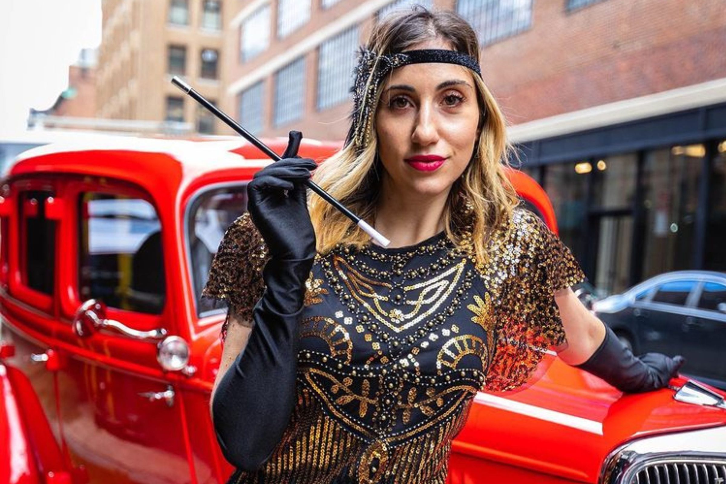 Woman posing in front of a vintage car